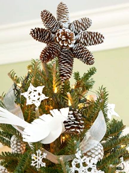 a Christmas tree with lights, white faux birds, pinecones and a large pinecone tree topper is a cool rustic idea for the holidays